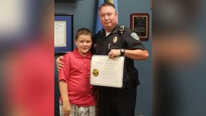 Boy adopted by police officer after rescuing him from child abuse is now a straight-A student